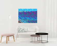 Load image into Gallery viewer, We Are One is an abstract landscape artwork featuring the ocean and trees in blues and some pinks placed on topic of a small sofa in a room.