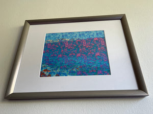 We Are One is an abstract landscape artwork featuring the ocean and trees in blues and some pinks placed with a frame.